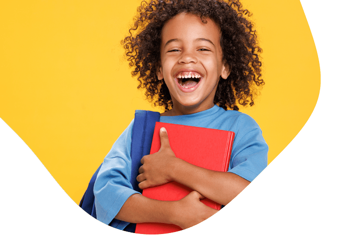 kid laughing while holding school books